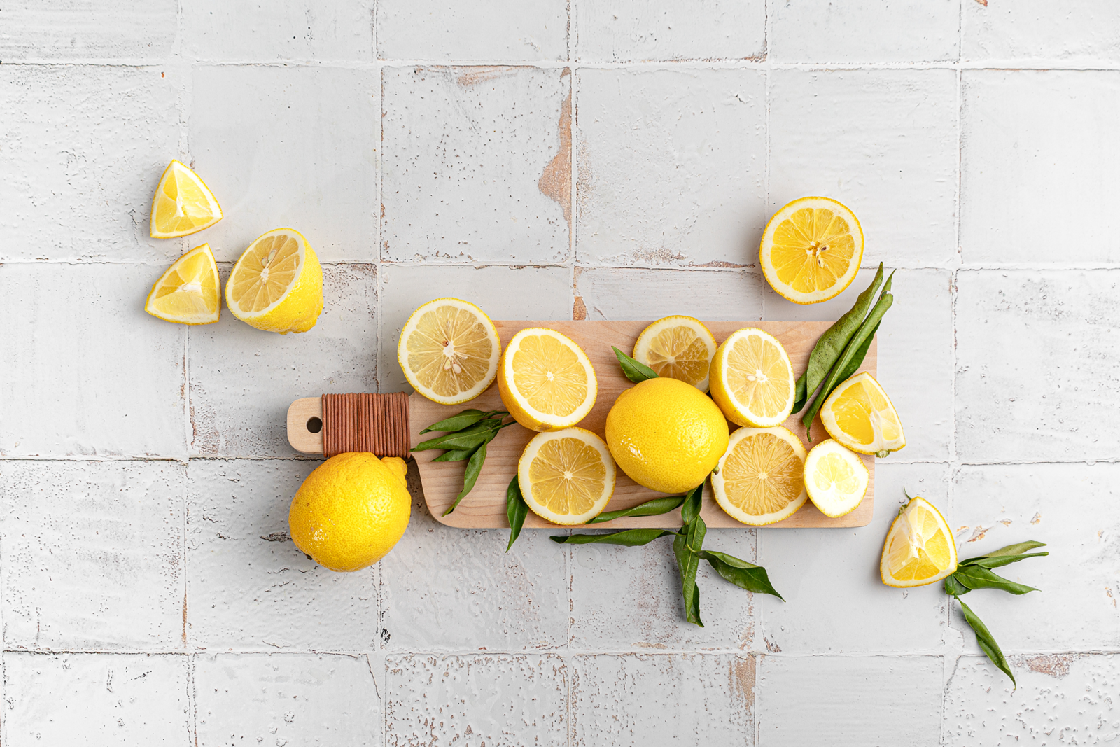 An assembly of entire and cut lemons on white background