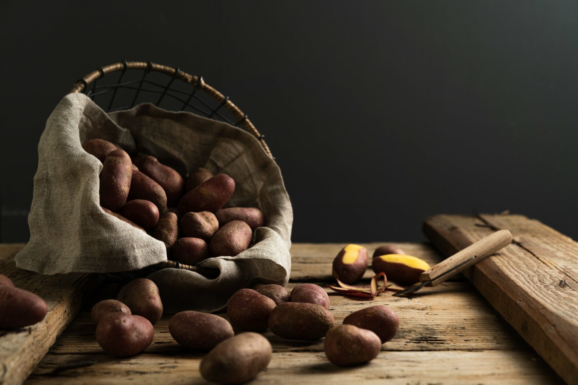 Red-skinned potatoes fallen out of a basket