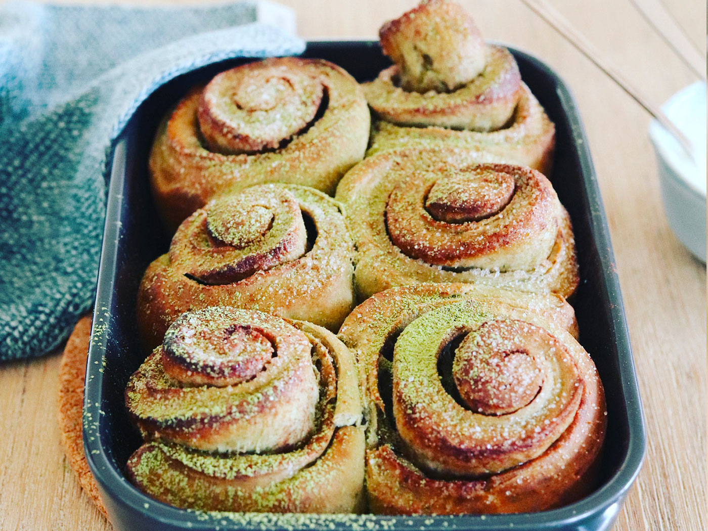 Matcha cinnamon rolls in a baking pan